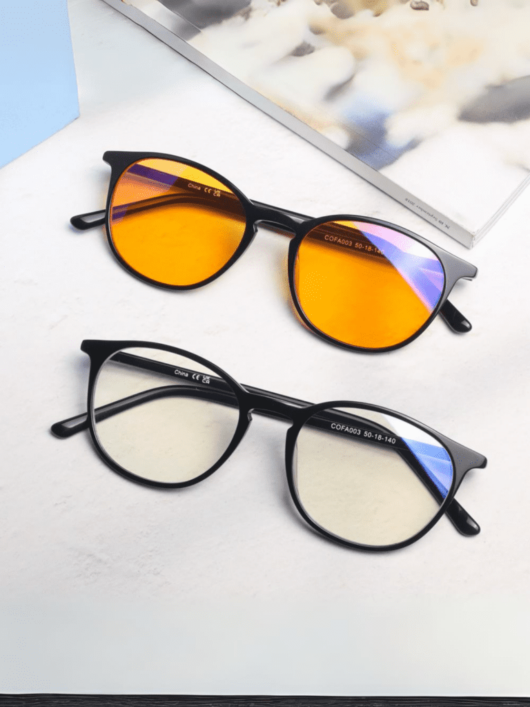 To sorte runde briller på lys baggrund, øverst med orange solglas, nederst med klare blåreflekterende linser