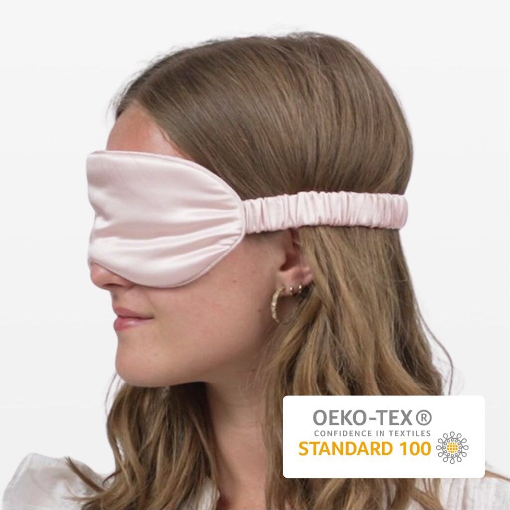 Rosa silkeøjenmaske med elastisk bånd på kvinde i profil, blødt luksuriøst stof og OEKO-TEX Standard 100 mærke