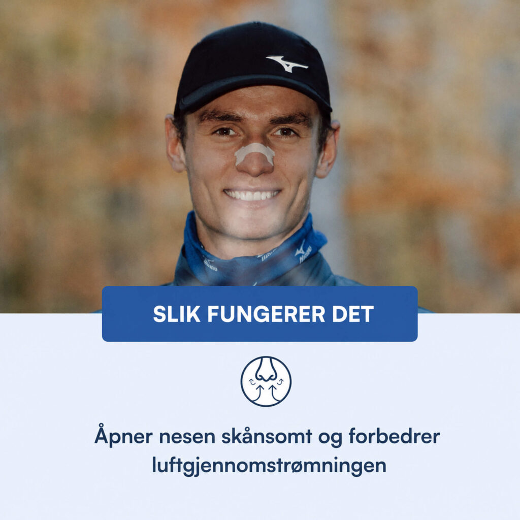 Smilende mann med nesestripe over neseryggen, svart caps og blå halseduk