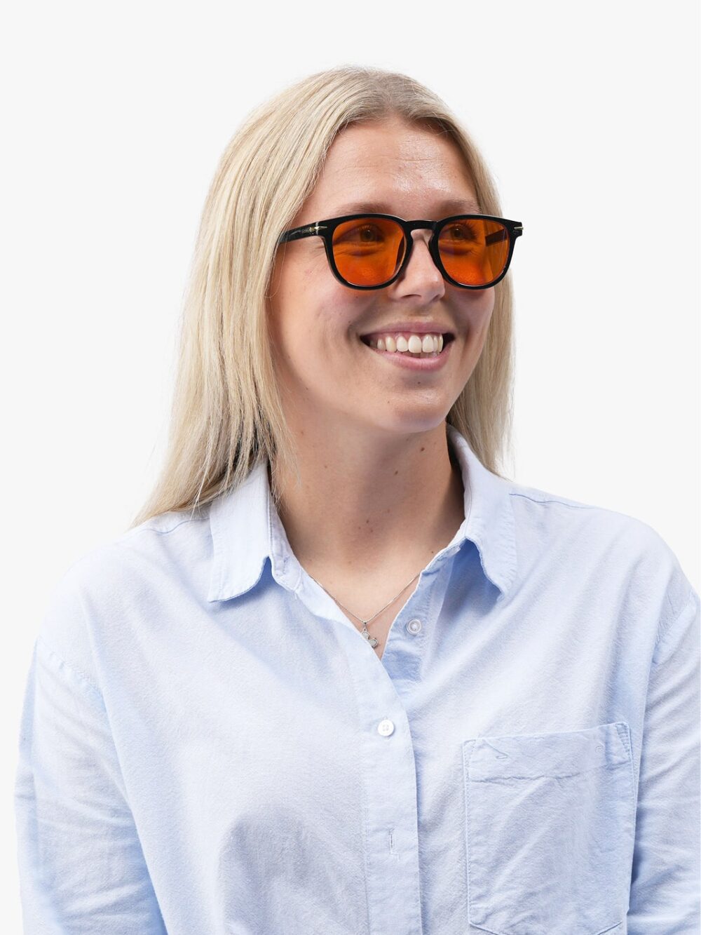 Smilende kvinde med langt blondt hår iført sorte briller med orange linser og lyseblå skjorte