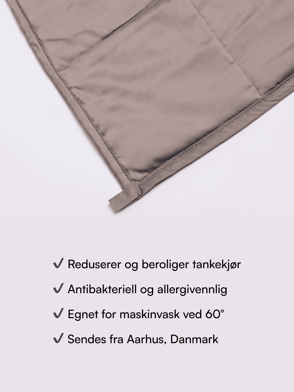 Gråt vægttæppe hjørne med synlige sømme og stroppe, produktfordele listet under (antibakteriel, maskinvask 60°)