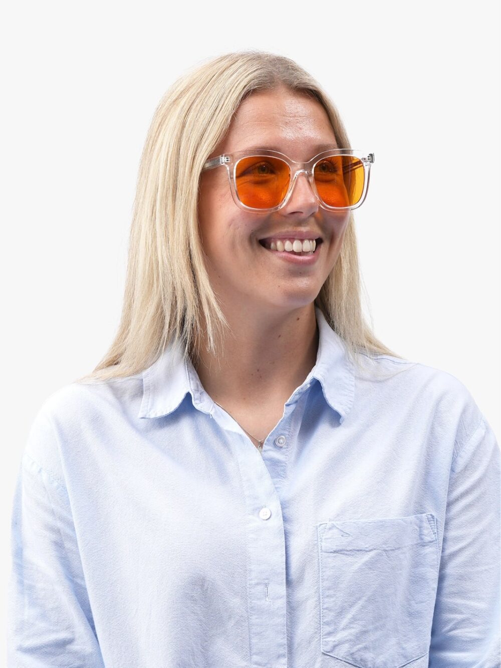Smilende kvinde med blondt hår i gennemsigtige solbriller med orange linser og lyseblå skjorte
