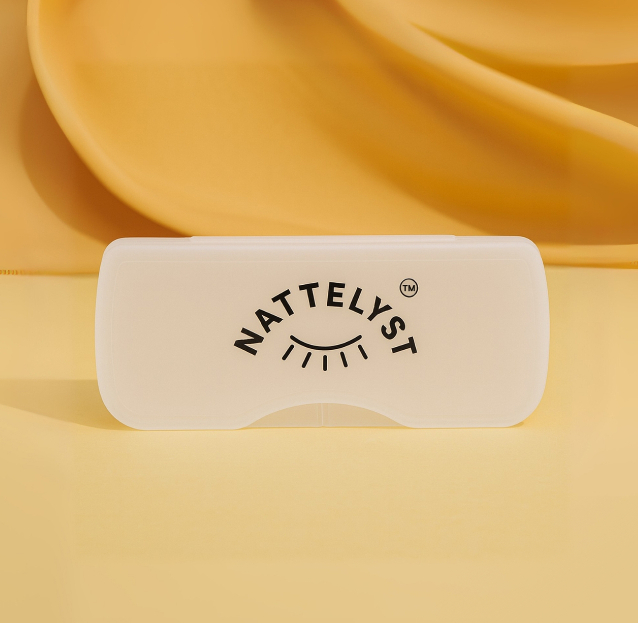 Gennemsigtigt hvidt clip-on-etui med sort NATTELYST-logo på gul baggrund
