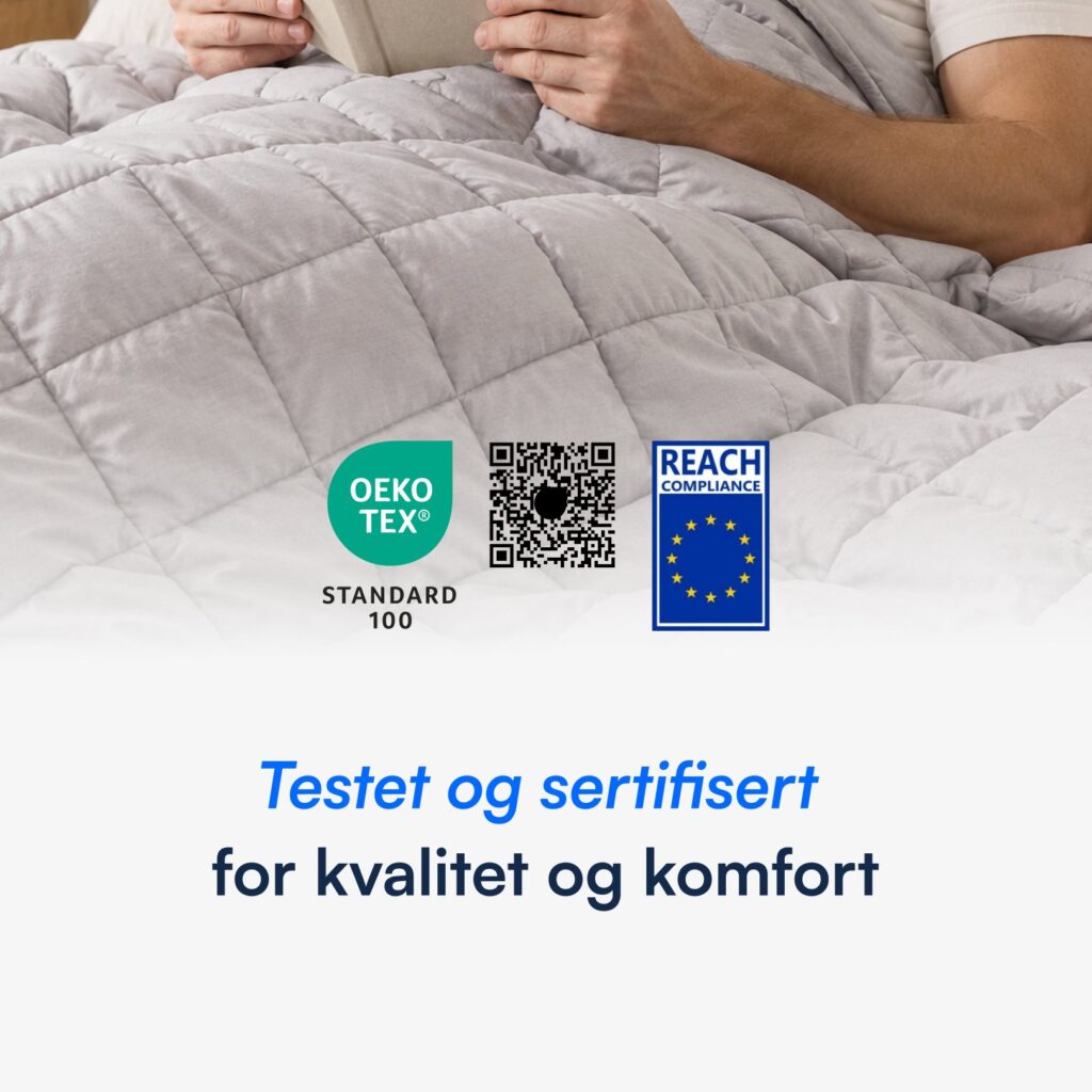 Person under lysegrå vektet dyne som leser bok, med OEKO‑TEX og REACH sertifiseringssymboler